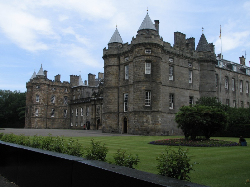 a castle with a clock on the side of Holyrood Palace